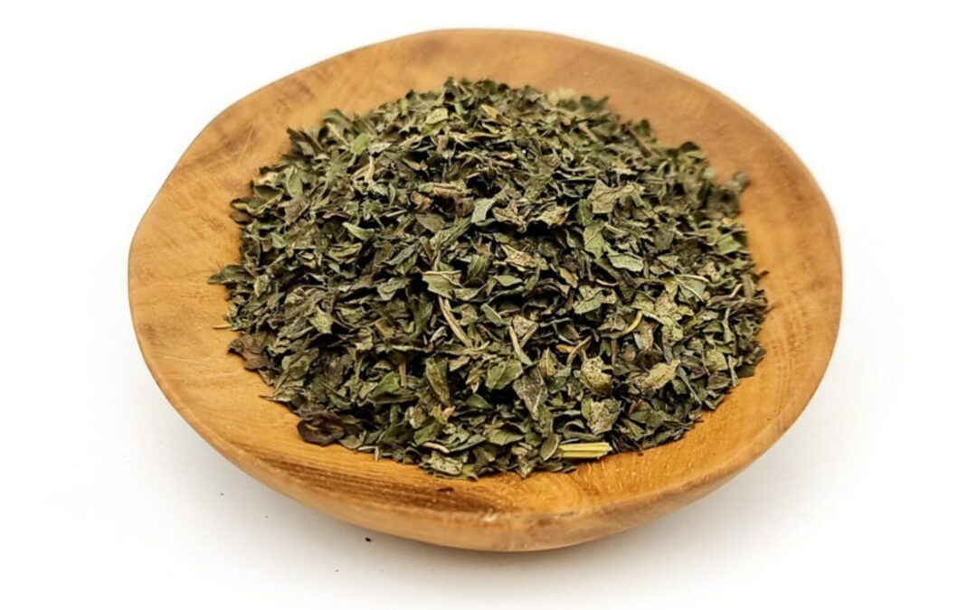 Dried peppermint leaves in a wooden dish.