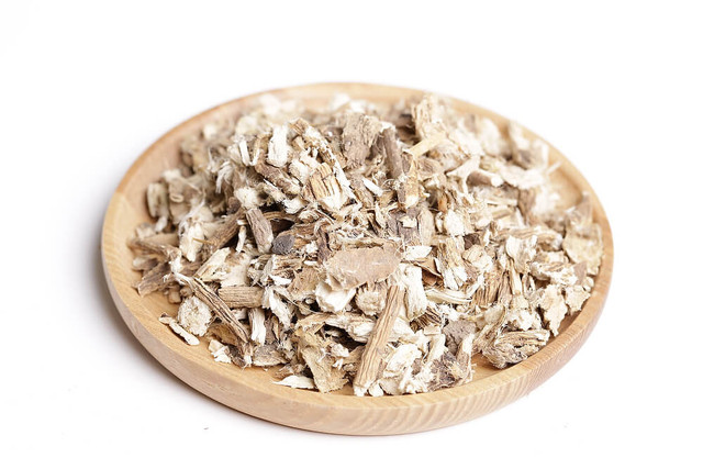 Chopped marshmallow root in a wooden dish.