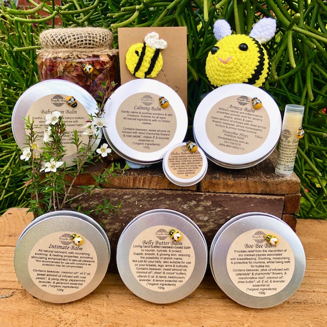 A selection of HoneyBee Hives beeswax balm tins together with honey and handmade bee gifts